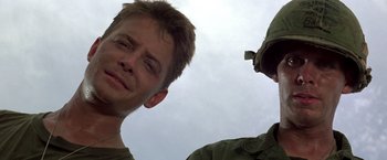 Movie still from “Casualties of War” (1989), directed by Brian De Palma – Two men standing next to each other on a cloudy day; Close Up shot, Low angle