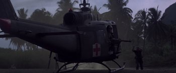 Movie still from “Casualties of War” (1989), directed by Brian De Palma – A military helicopter with a red and white cross on it's side; Extreme Wide shot, Low angle
