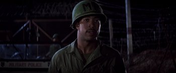 Movie still from “Casualties of War” (1989), directed by Brian De Palma – A man wearing a green helmet and a green jacket; Close Up shot, Low angle