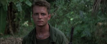 Movie still from “Casualties of War” (1989), directed by Brian De Palma – A person holding a gun; Close Up shot, Low angle