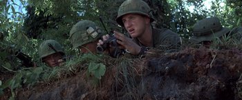 Movie still from “Casualties of War” (1989), directed by Brian De Palma – Two men in military fatigues are looking through binoculars; Medium shot, Low angle