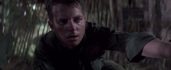Movie still from “Casualties of War” (1989), directed by Brian De Palma – A man in military fatigues looking at the camera; Close Up shot, Low angle