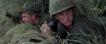 Movie still from “Casualties of War” (1989), directed by Brian De Palma – Two men in fatigues are laying in the grass; Close Up shot, Low angle