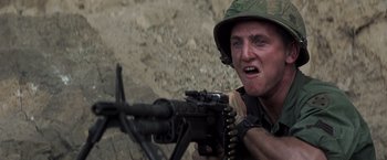Movie still from “Casualties of War” (1989), directed by Brian De Palma – A man in a military uniform is holding a gun; Close Up shot, Low angle