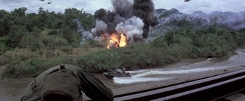 Movie still from “Casualties of War” (1989), directed by Brian De Palma – A boat on water near a body of water with smoke billowing out of it; Extreme Wide shot, Low angle