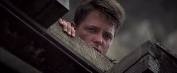 Movie still from “Casualties of War” (1989), directed by Brian De Palma – A person leaning on a wooden post; Close Up shot, Low angle