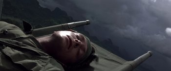 Movie still from “Casualties of War” (1989), directed by Brian De Palma – A person is laying on the ground with a stick in their head; Close Up shot, High angle