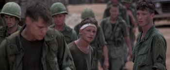 Movie still from “Casualties of War” (1989), directed by Brian De Palma – A group of men in fatigues walking on a dirt field; Close Up shot, Over the shoulder angle
