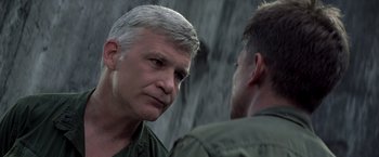 Movie still from “Casualties of War” (1989), directed by Brian De Palma – Two men are talking to each other outside; Close Up shot, Over the shoulder angle