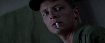 Movie still from “Casualties of War” (1989), directed by Brian De Palma – A person with a cigarette in his mouth; Close Up shot, Low angle