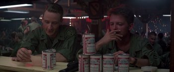 Movie still from “Casualties of War” (1989), directed by Brian De Palma – A couple of men sitting at a table with cans of beer; Close Up shot, Low angle