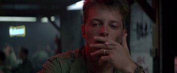 Movie still from “Casualties of War” (1989), directed by Brian De Palma – A young man smoking a cigarette in a dark room; Close Up shot, Low angle