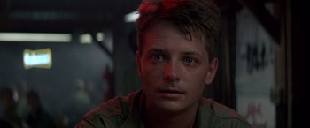 Movie still from “Casualties of War” (1989), directed by Brian De Palma – A person wearing a green shirt; Close Up shot, Low angle