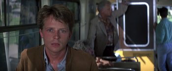 Movie still from “Casualties of War” (1989), directed by Brian De Palma – A young man in a brown jacket is on a train; Close Up shot, Over the shoulder angle