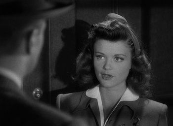 Movie still from “Cat People” (1942), directed by Jacques Tourneur – A black - and - white photo of a woman looking at herself in a mirror; Close Up shot, Over the shoulder angle