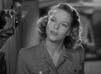 Movie still from “Cat People” (1942), directed by Jacques Tourneur – A black and white photo of a woman in a military uniform; Close Up shot, Over the shoulder angle