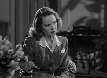 Movie still from “Cat People” (1942), directed by Jacques Tourneur – A black and white photo of a woman sitting at a table; Close Up shot, Over the shoulder angle