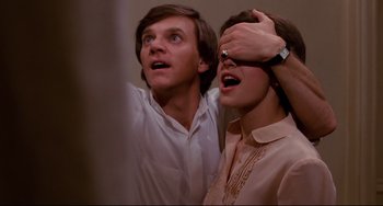 Movie still from “Cat People” (1982), directed by Paul Schrader – A man and a woman standing next to each other; Close Up shot, Low angle