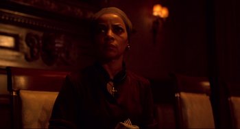 Movie still from “Cat People” (1982), directed by Paul Schrader – A woman with a cross on her head in a dark room; Medium shot, Low angle