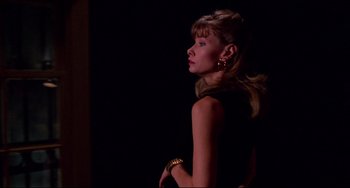 Movie still from “Cat People” (1982), directed by Paul Schrader – A woman in a black dress is standing in the dark; Medium shot, Low angle