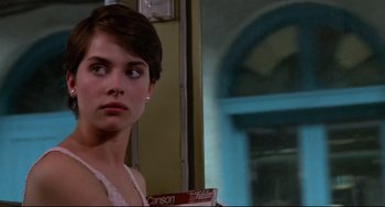 Movie still from “Cat People” (1982), directed by Paul Schrader – A young woman standing in front of a building; Close Up shot, Over the shoulder angle