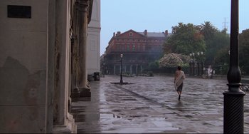Movie still from “Cat People” (1982), directed by Paul Schrader – A person walking in the rain near a building; Extreme Wide shot, High angle