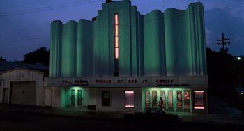 Movie still from “Cat People” (1982), directed by Paul Schrader – A church of god in christ is lit up at night; Extreme Wide shot, Low angle