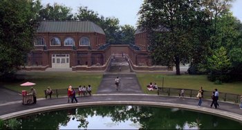 Movie still from “Cat People” (1982), directed by Paul Schrader – A group of people sitting on a bench near a pond; Extreme Wide shot, High angle