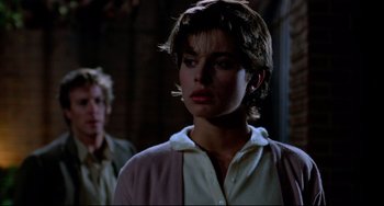 Movie still from “Cat People” (1982), directed by Paul Schrader – A man and a woman standing next to each other in front of a brick wall; Close Up shot, Over the shoulder angle