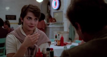 Movie still from “Cat People” (1982), directed by Paul Schrader – A woman sitting at a table in front of a man; Close Up shot, Over the shoulder angle