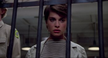 Movie still from “Cat People” (1982), directed by Paul Schrader – A woman standing behind bars in front of a window; Close Up shot, Low angle