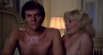 Movie still from “Cat People” (1982), directed by Paul Schrader – A man and a woman sitting next to each other in front of a lamp; Close Up shot, Over the shoulder angle