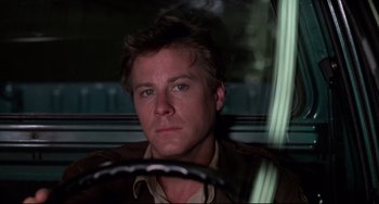 Movie still from “Cat People” (1982), directed by Paul Schrader – A person sitting in a car; Close Up shot, Low angle