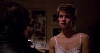 Movie still from “Cat People” (1982), directed by Paul Schrader – A young woman in a white bra looking at a man in a black suit; Close Up shot, Over the shoulder angle