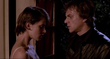 Movie still from “Cat People” (1982), directed by Paul Schrader – A man and a woman standing next to each other in front of a building; Close Up shot, Low angle