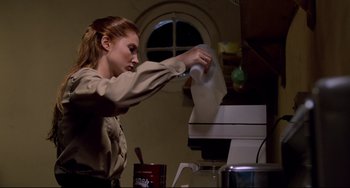 Movie still from “Cat People” (1982), directed by Paul Schrader – A woman in brown shirt cleaning a paper towel; Medium shot, Low angle