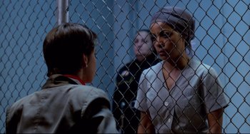 Movie still from “Cat People” (1982), directed by Paul Schrader – A woman and a boy are standing in front of a chain link fence; Close Up shot, Over the shoulder angle
