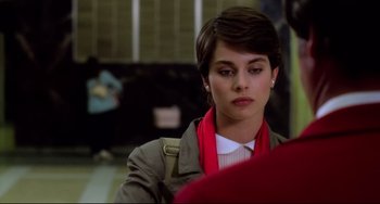 Movie still from “Cat People” (1982), directed by Paul Schrader – A woman with short brown hair wearing a jacket and a red scarf; Close Up shot, Over the shoulder angle