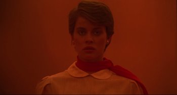 Movie still from “Cat People” (1982), directed by Paul Schrader – A woman wearing a yellow shirt and a red neck scarf; Close Up shot, Low angle