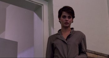 Movie still from “Cat People” (1982), directed by Paul Schrader – A woman with short hair is posing for a picture; Medium shot, Low angle