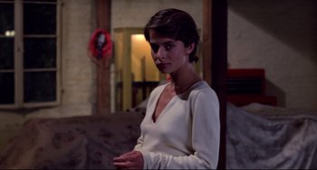 Movie still from “Cat People” (1982), directed by Paul Schrader – A woman standing in a room with her hands in her pockets; Medium shot, Over the shoulder angle