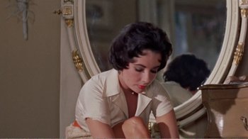Movie still from “Cat on a Hot Tin Roof” (1958), directed by Richard Brooks – A woman sitting in front of a round mirror; Medium shot, High angle