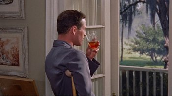 Movie still from “Cat on a Hot Tin Roof” (1958), directed by Richard Brooks – A man holding a glass of wine in his hand; Medium shot, Over the shoulder angle