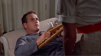 Movie still from “Cat on a Hot Tin Roof” (1958), directed by Richard Brooks – A man holding a tray with a drink in his hand; Medium shot, Low angle
