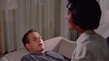Movie still from “Cat on a Hot Tin Roof” (1958), directed by Richard Brooks – A man and a woman sitting on a couch talking to each other; Medium shot, Over the shoulder angle