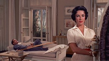 Movie still from “Cat on a Hot Tin Roof” (1958), directed by Richard Brooks – A woman sitting on a couch in a living room; Medium shot, Low angle