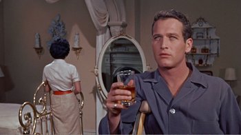 Movie still from “Cat on a Hot Tin Roof” (1958), directed by Richard Brooks – A man holding a glass in front of a mirror; Close Up shot, Over the shoulder angle