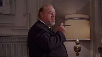 Movie still from “Cat on a Hot Tin Roof” (1958), directed by Richard Brooks – A man in a suit and tie holding a cigar; Medium shot, Low angle