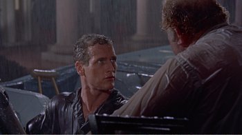 Movie still from “Cat on a Hot Tin Roof” (1958), directed by Richard Brooks – A man sitting in front of another man in the rain; Close Up shot, Over the shoulder angle