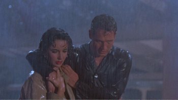 Movie still from “Cat on a Hot Tin Roof” (1958), directed by Richard Brooks – A man and a woman standing in the pouring rain; Medium shot, High angle